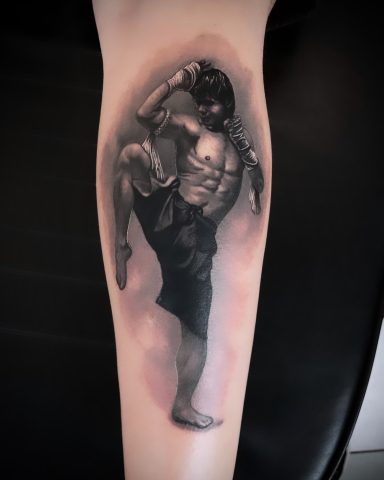Tattoo eines kämpfenden Mannes in dynamischer Pose auf einem Unterarm.