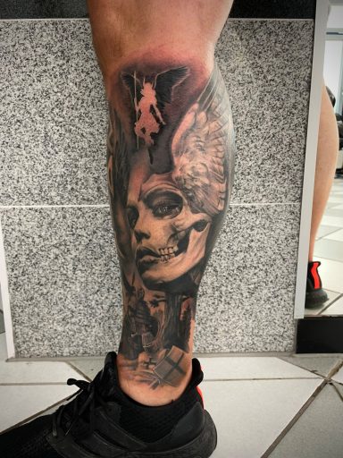 Tattoo auf dem Unterschenkel mit einer Frauenfigur und surrealen Elementen.