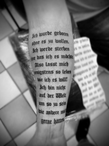 Tattoo auf dem Unterarm mit Text über persönliche Erfahrungen und Hindernisse.
