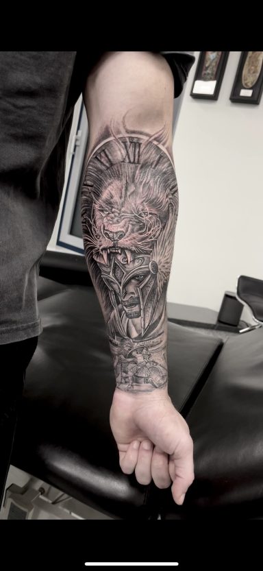 Tattoo auf einem Unterarm mit detaillierten, kunstvollen Mustern und Motiven.