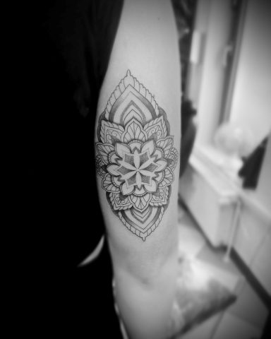Schwarz-weiß-Tattoo eines geometrischen Musters auf dem Unterarm.